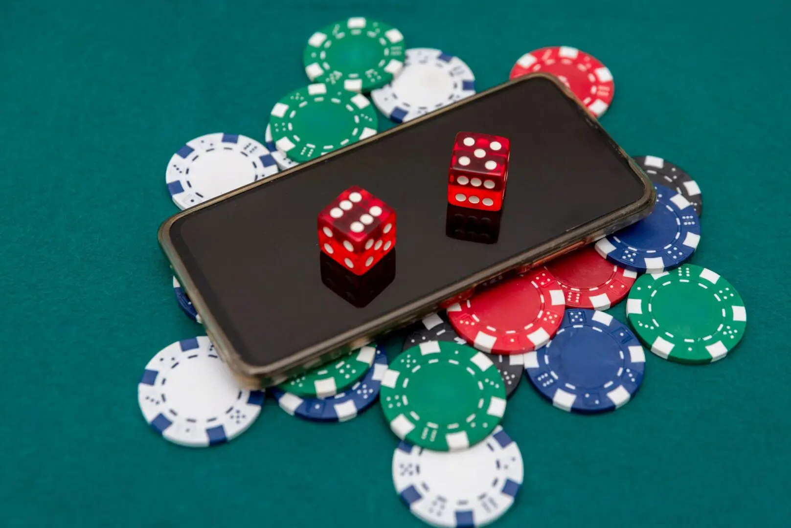 Smartphone on poker chips with red dice.